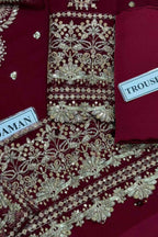 Close-up of a deep maroon traditional garment with extensive gold and silver embroidery, featuring labels that read 'MAHAN' and 'TROUSHE'.