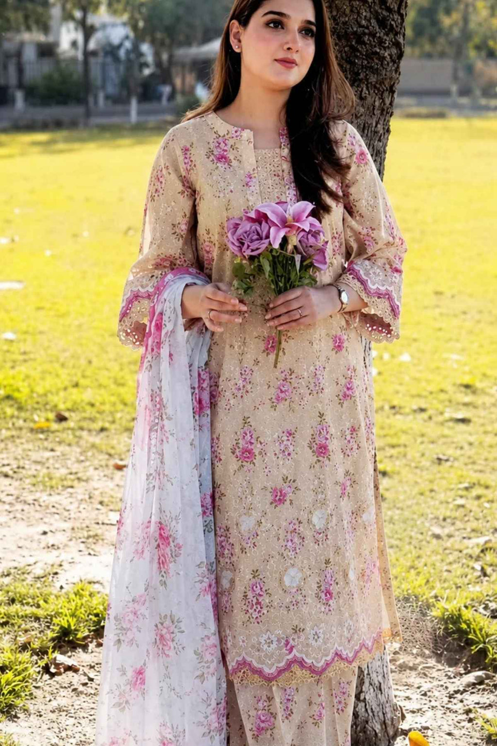 Woman in a floral dress holding flowers in an outdoor setting
