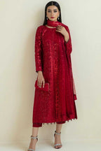 Woman wearing a red traditional outfit with a matching dupatta against a beige background