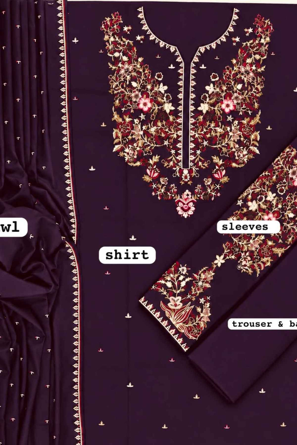 A dark purple salwar suit set with intricate gold, red, and pink floral embroidery on the shirt yoke and sleeves, accompanied by a matching embroidered dupatta.