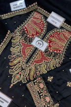 Black embroidered choli top with red paisley neckline, gold and pink floral embroidery, and multiple fabric labels showing details like 'CHIP ON DUPATTA' and 'EMBROIDERED NECK'.