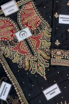 Black embroidered women's salwar suit fabric set with detailed red, gold, and pink paisley and floral embroidery. The image shows close-up views of the neckline, sleeves, front panel, and dupatta, each labeled with a white tag.