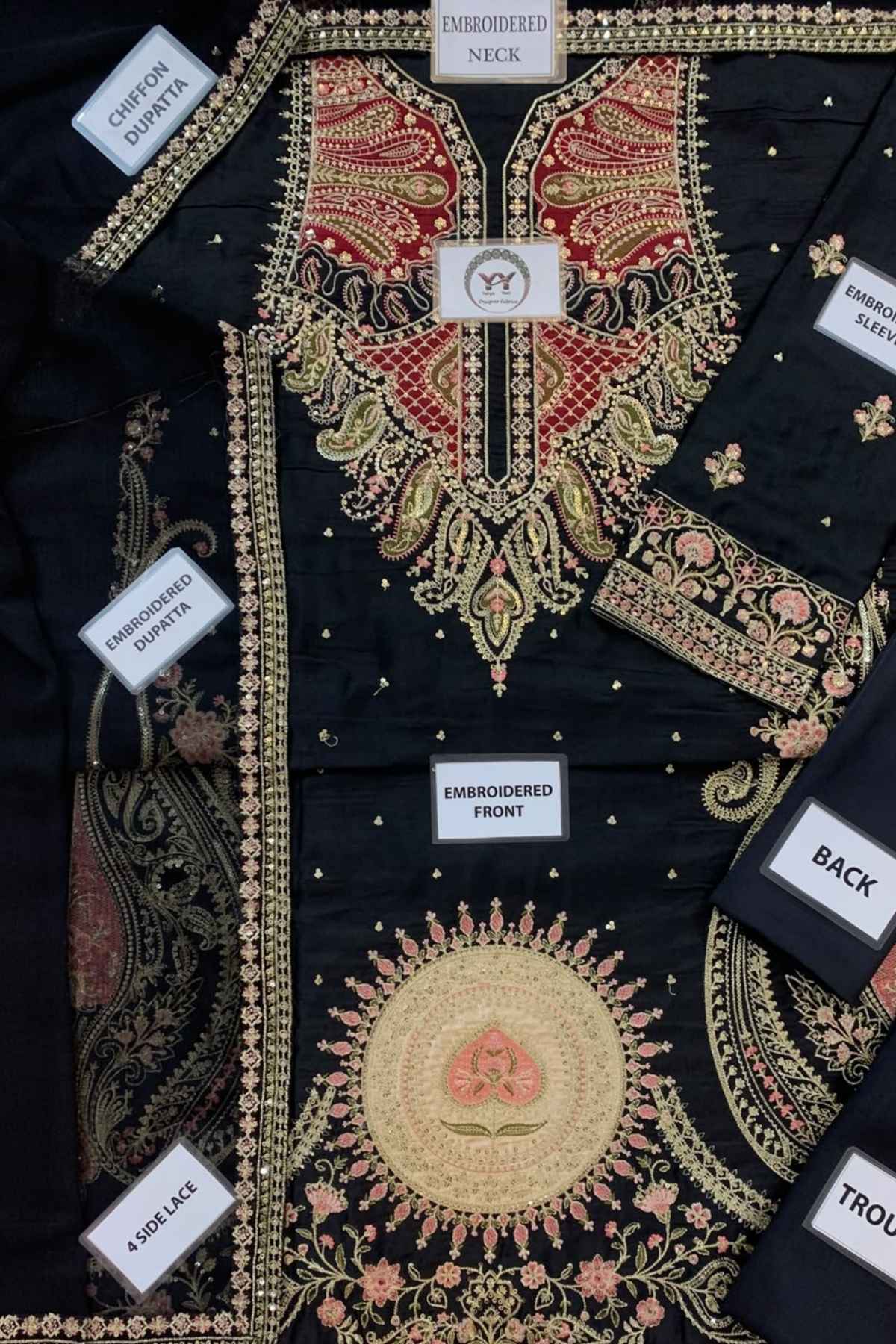 Black embroidered traditional kurta laid flat, showing the front, neck, sleeves, and back panels. The kurta features intricate gold, red, and pink floral and paisley embroidery with white labels indicating different sections.