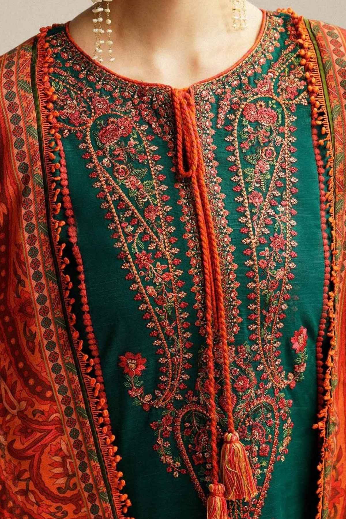 Close-up of a dark teal green embroidered kurta with intricate red, orange, and gold floral embroidery, featuring a tie-neck and tassel, paired with a matching patterned dupatta.