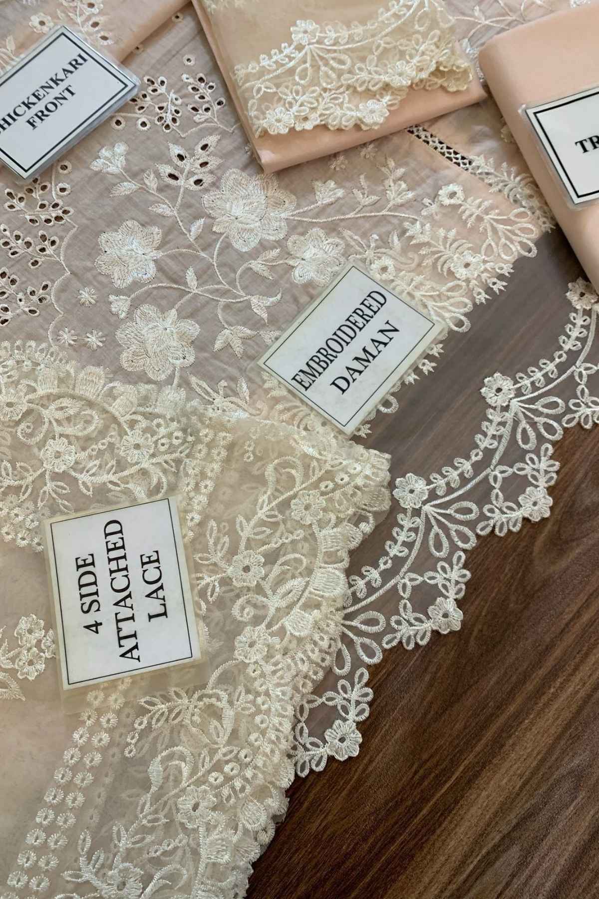 Lace fabric with attached lace and embroidered daman on a wooden surface