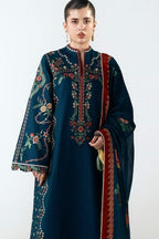 A woman modeling a dark teal traditional embroidered kurta with a matching dupatta. The kurta features intricate floral embroidery in red, gold, and green on the chest, sleeves, and hem, with a red border on the dupatta.