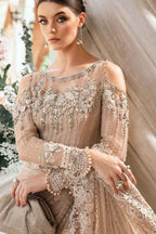 Woman wearing a beaded and embroidered dress with a soft focus background