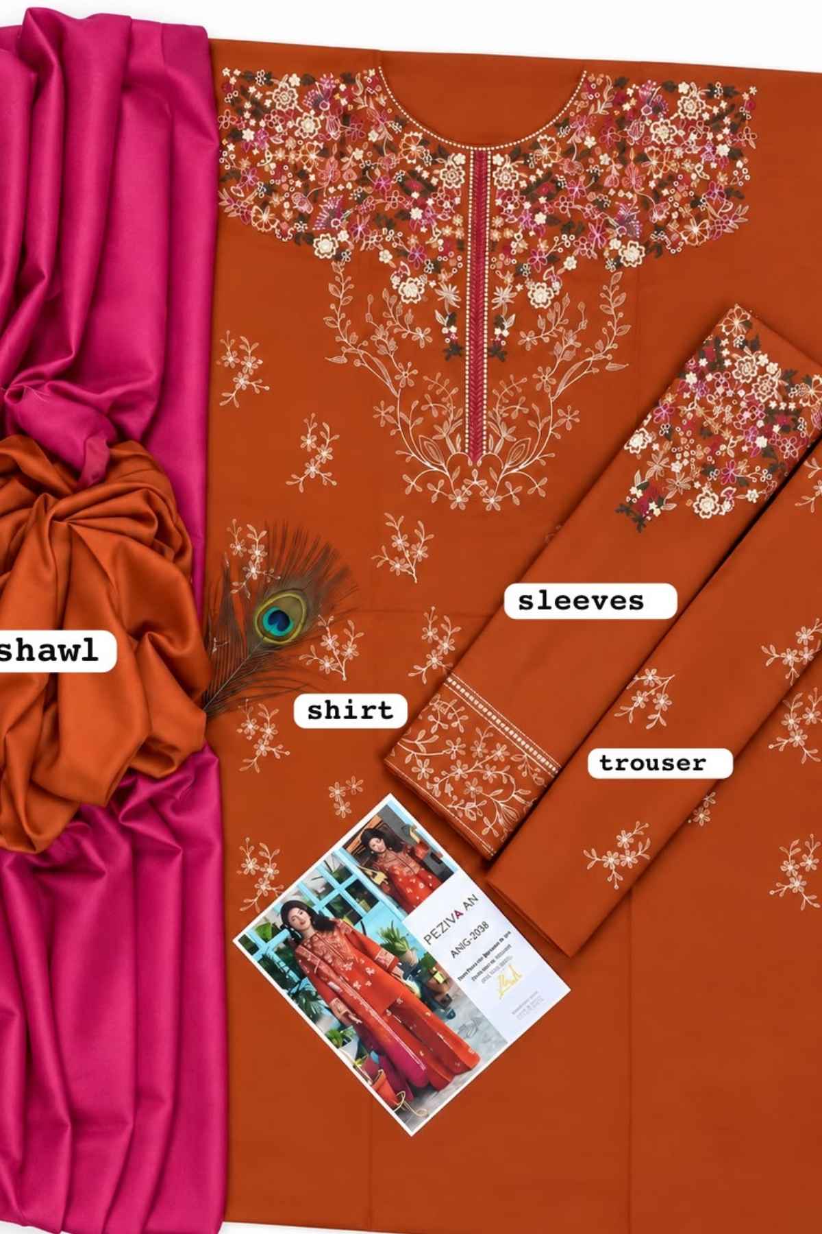 A flat-lay presentation of a traditional Indian salwar suit set in rust orange, featuring a printed kurta with floral embroidery, matching printed sleeves and trouser, a vibrant magenta pink shawl, and a decorative peacock feather. White labels identify the components: 'shirt', 'sleeves', 'trouser', and 'shawl'.