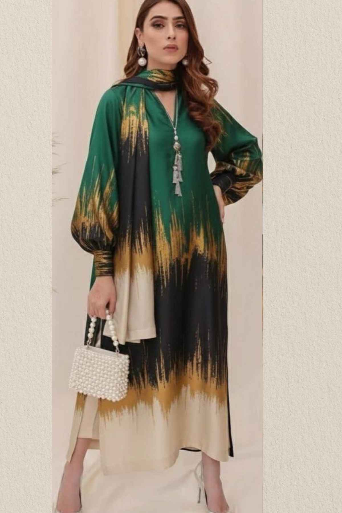 Woman wearing a green, black, and yellow tie-dye outfit with a beige skirt.