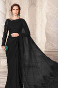 Woman wearing a black saree with a textured background