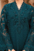 A close-up of a dark teal lace tunic with intricate floral embroidery, beadwork, and a scalloped V-neckline, shown on a model.