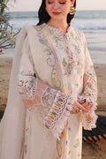 Woman wearing a traditional embroidered outfit with a beach in the background