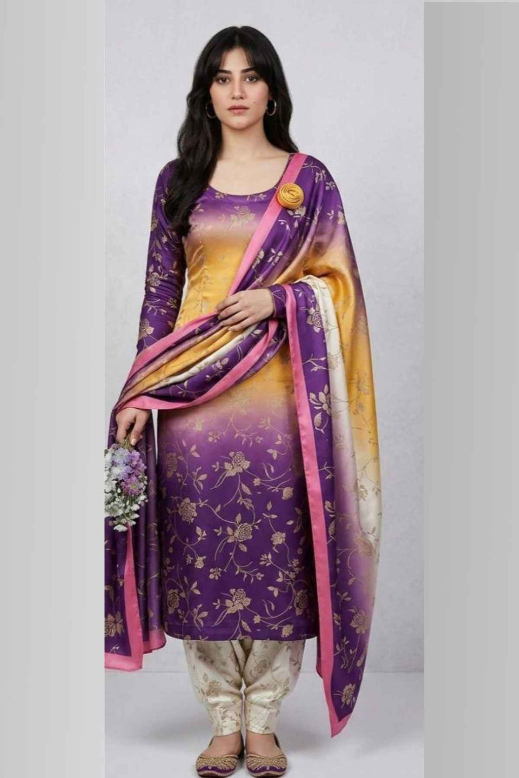 Woman wearing a purple and yellow traditional outfit with a matching dupatta on a white background